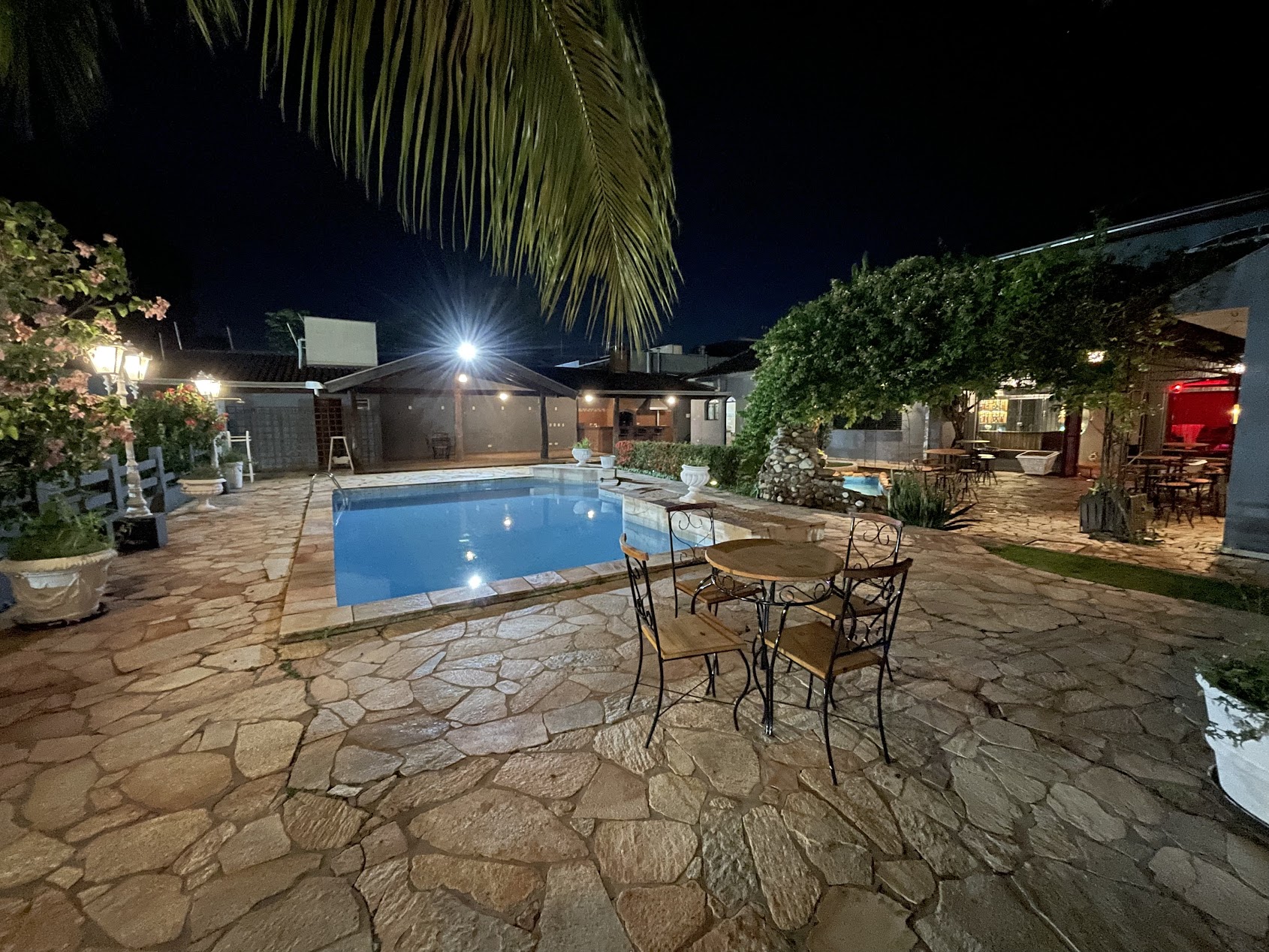 Pátio externo da Enigma com piscina e mesas ao ar livre
